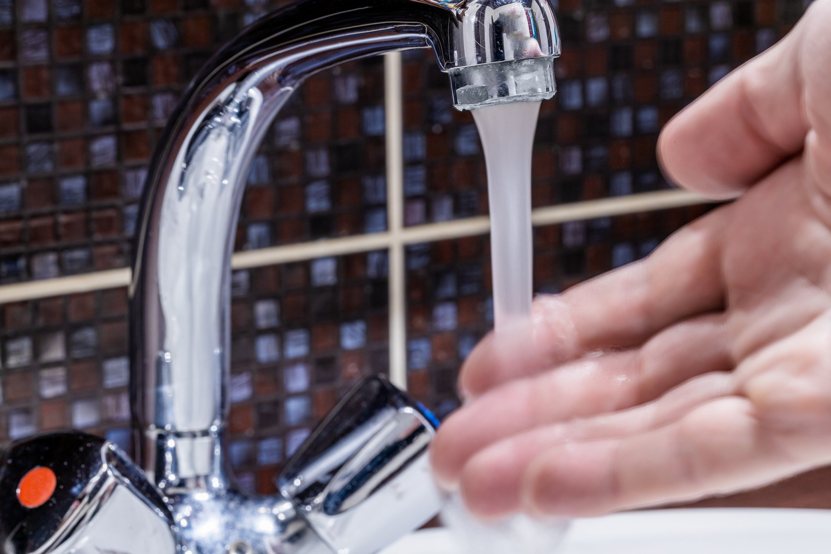 Hand Under Running Water from Faucet